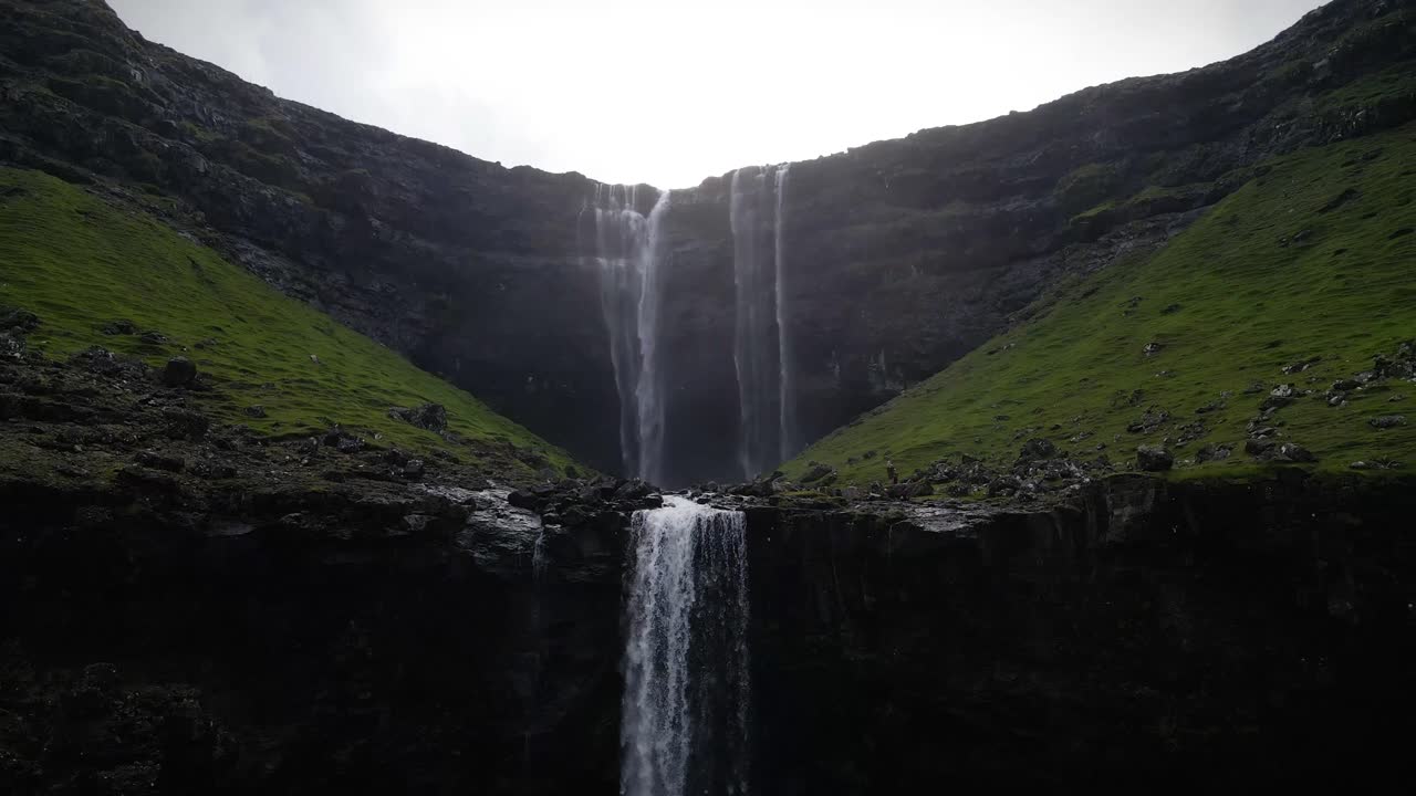 fossa cascada: poderosas corrientes de agua se sumergen desde un alto acantilado en un profundo desfiladero, creando un espectáculo impresionante de la belleza cruda de la naturaleza en las remotas islas feroe.