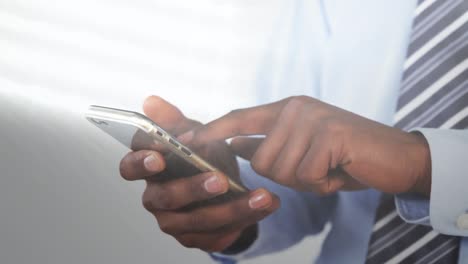 Animation-of-light-spots-over-african-american-man-using-smartphone