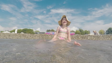 Ein-Cooles-Mädchen-In-Rosa-Badeanzug-Und-Breitkrempiger-Hut-Vergnügt-Sich-Am-Strand-Spielen-Seaside