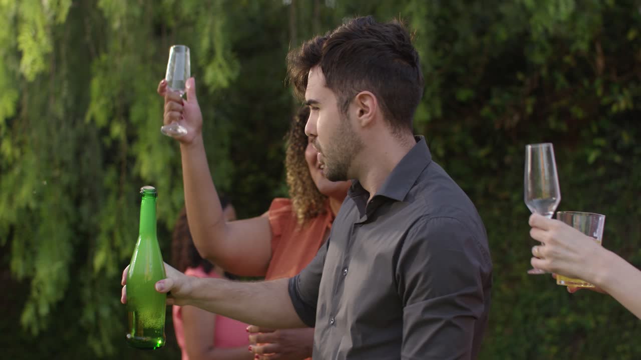 Friends celebrating and toasting with drinks at an outdoor gathering
