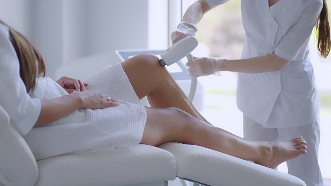 Laser epilation. Woman getting laser hair removal procedure on her legs. Beauty laser treatment salon clinic cosmetology beautician professional profession body care concept