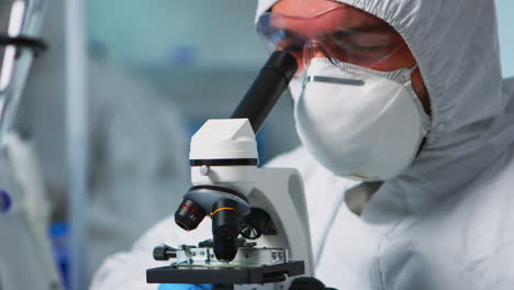 Close-up-of-chemist-doctor-analysing-virus-using-microscope