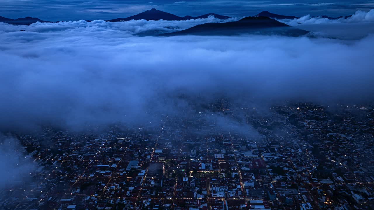 DRONE TIME-LAPSE OF URUAPAN, MICHOACÁN CITY AFTER SUNSET WITH CLOUDS PASSING BY