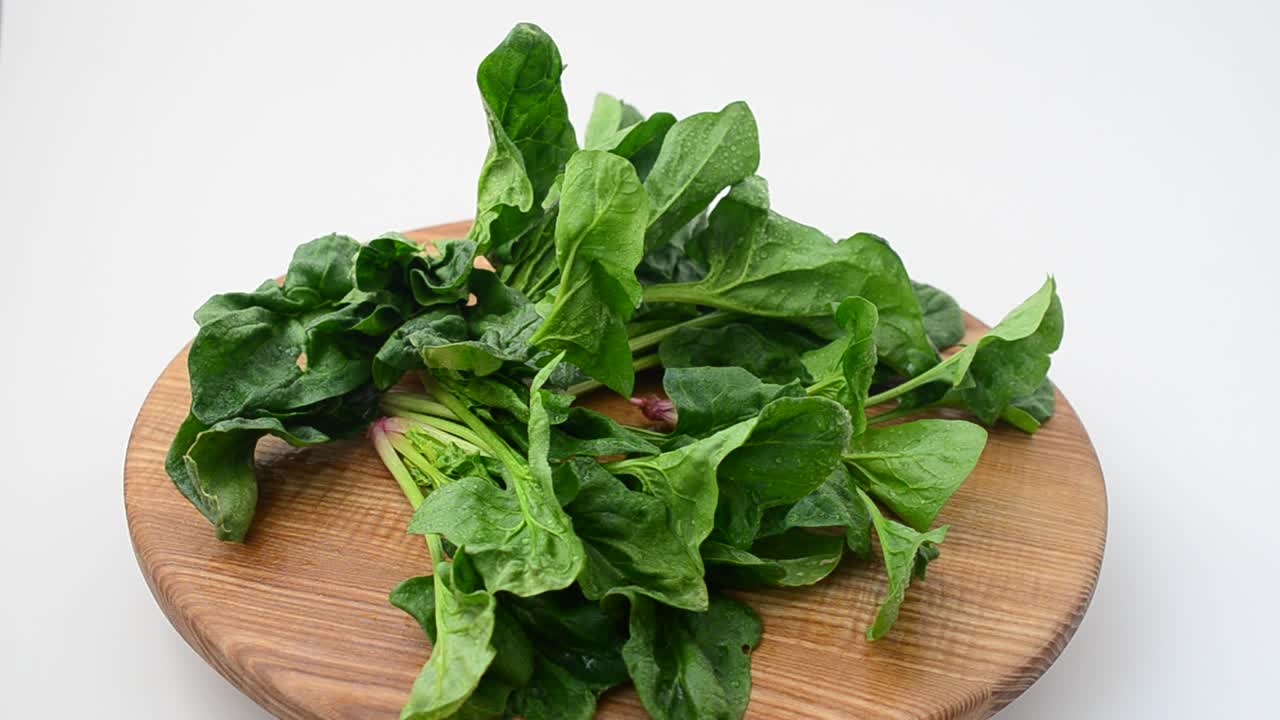 Foglie di spinaci su un tagliere. Riprese in movimento.