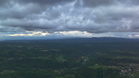 drone timelapse of chichicastenango’s mountains and forests beneath heavy storm clouds, creating a dramatic and moody aerial landscape