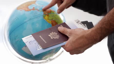 male traveler spinning globe with passport and airplane ticket in hand picking destination hd