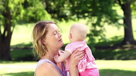 Happy-mother-playing-with-her-baby-girl-in-the-park