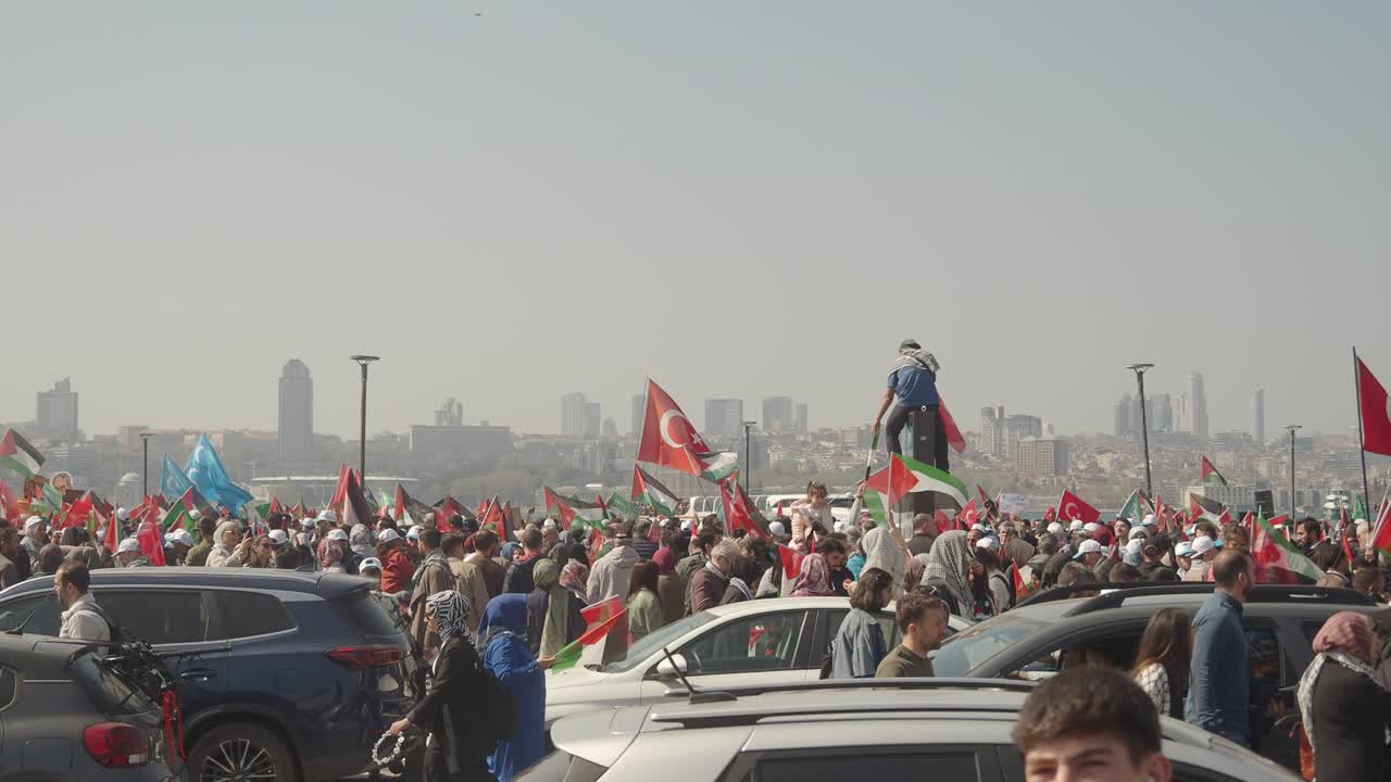 Large crowd with Turkish and Palestinian flags at a demonstration in a city