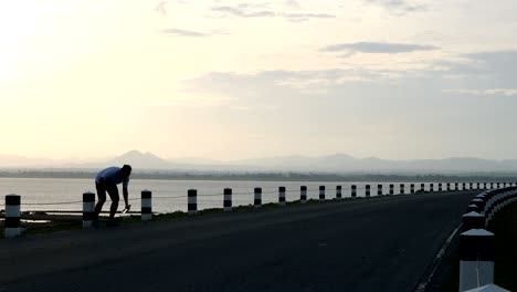 los hombres usan un teléfono inteligente tomando fotos de sí mismos y corriendo en el tiempo durante el amanecer en el ejercicio de la carretera de la presa. vivir el concepto de estilo de vida saludable.