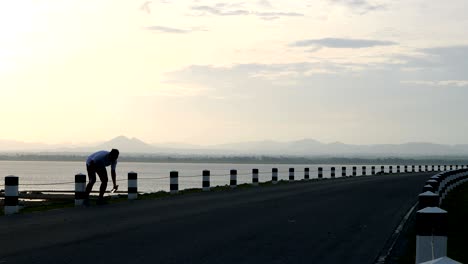 men use a smartphone taking pictures of yourself and running in the time during sunrise on dam road exercise. living healthy lifestyle concept.