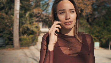 una mujer joven usando un teléfono inteligente al aire libre.