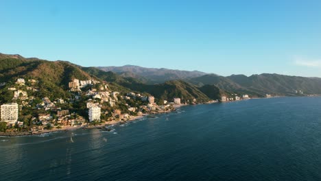 wide-panoramic-mountain-range-coastline-of-Puerto-Vallarta-Mexico-at-golden-hour-sunset,-aerial