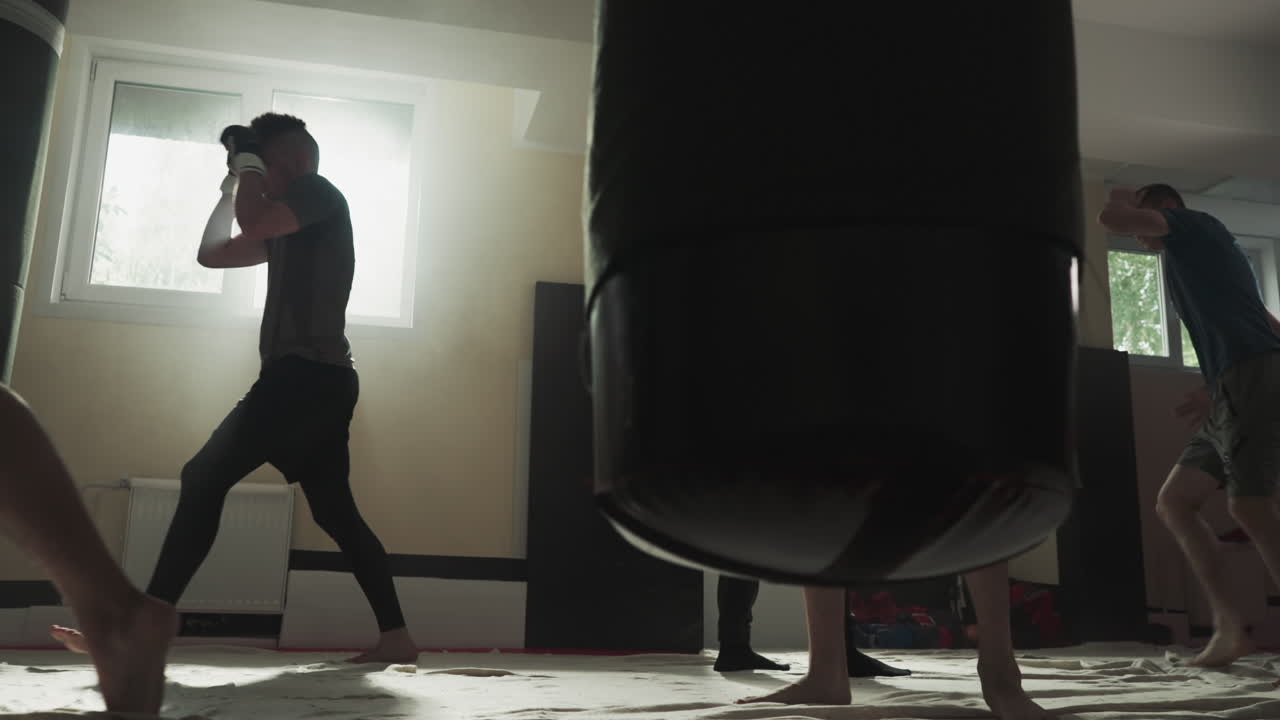 복싱 선수들은 스포츠 클럽에서 싱 장비를 사용하여 운동합니다. 맨발의 복싱 선수들은 체육관에서 느린 동작으로 경쟁을 위해 팀 훈련을 합니다. 무술 마스터