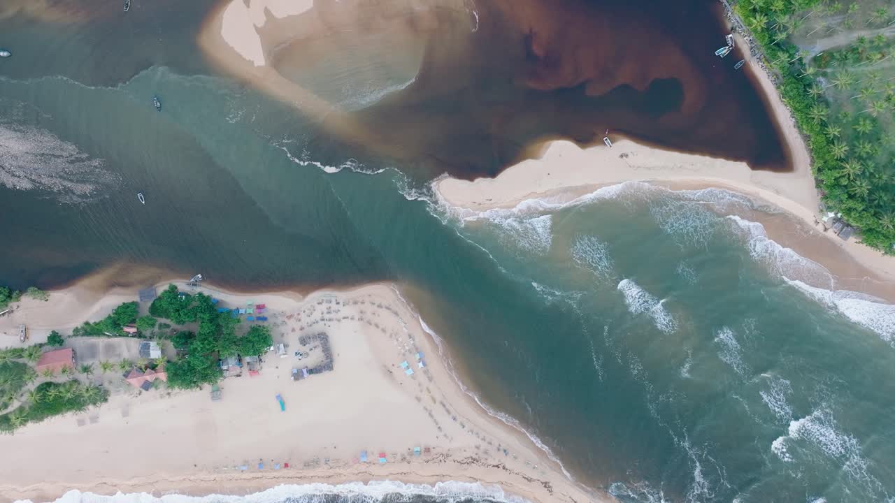vista aérea de arriba hacia abajo de la playa rural de la ciudad de caraiva bahía, brasil, con las olas del océano y la reunión del río