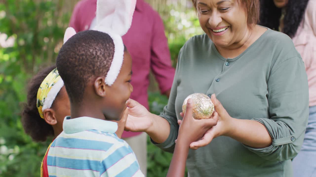 Animation of happy african american family searching for easter eggs in garden