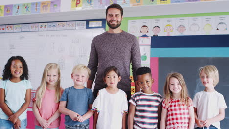 Porträt-Von-Grundschülern,-Die-Mit-Einem-Männlichen-Lehrer-Im-Klassenzimmer-Stehen