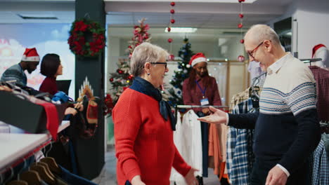 happy elderly couple dancing around in xmas ornate shopping mall clothing store, finally finding perfect gifts for family members at christmas gathering during winter holiday season