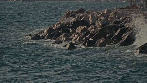 waves crashing on rocky shore in slow motion, naples, italy