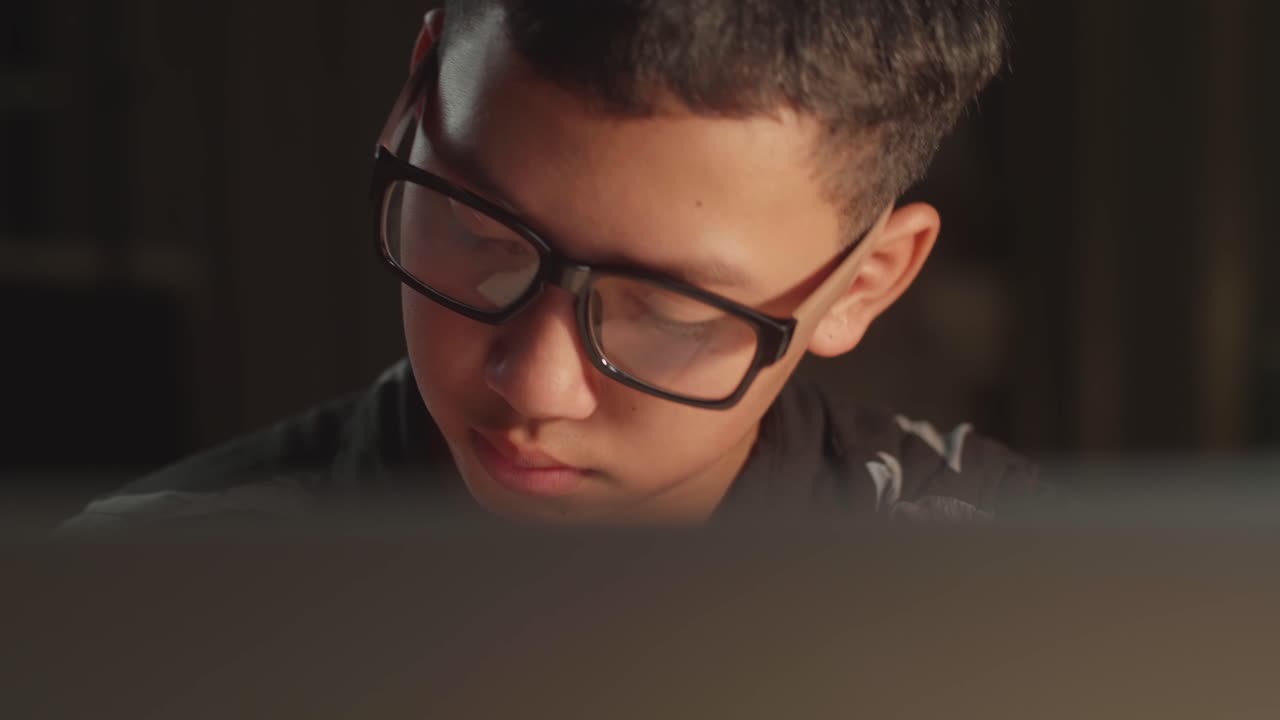 Close Up Teenage Boy Learning Online From Laptop At Night