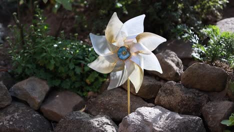 Close-up-of-beautiful-decorative-garden-windmill-in-flower-bed