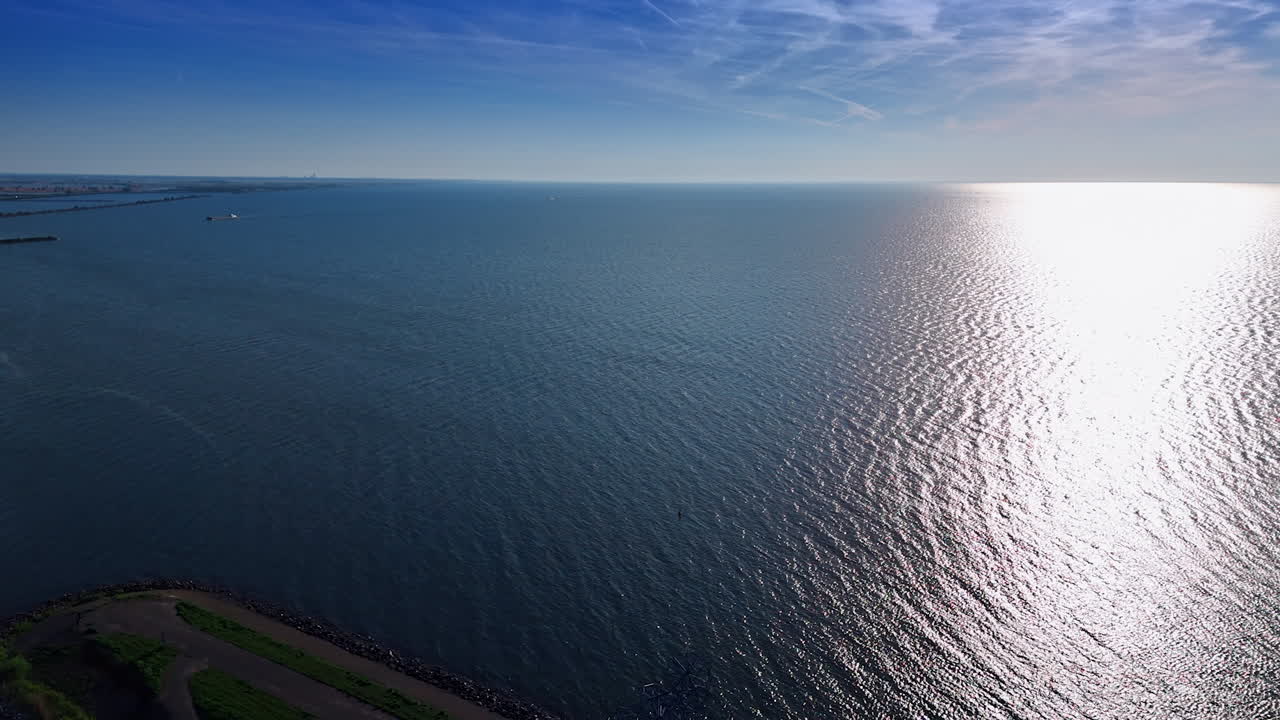 Gigantic steel figure of man made of steel. Land art hurking man at the dike of the Markermmer lake, Lelystad,the Netherlands. Aerial view.