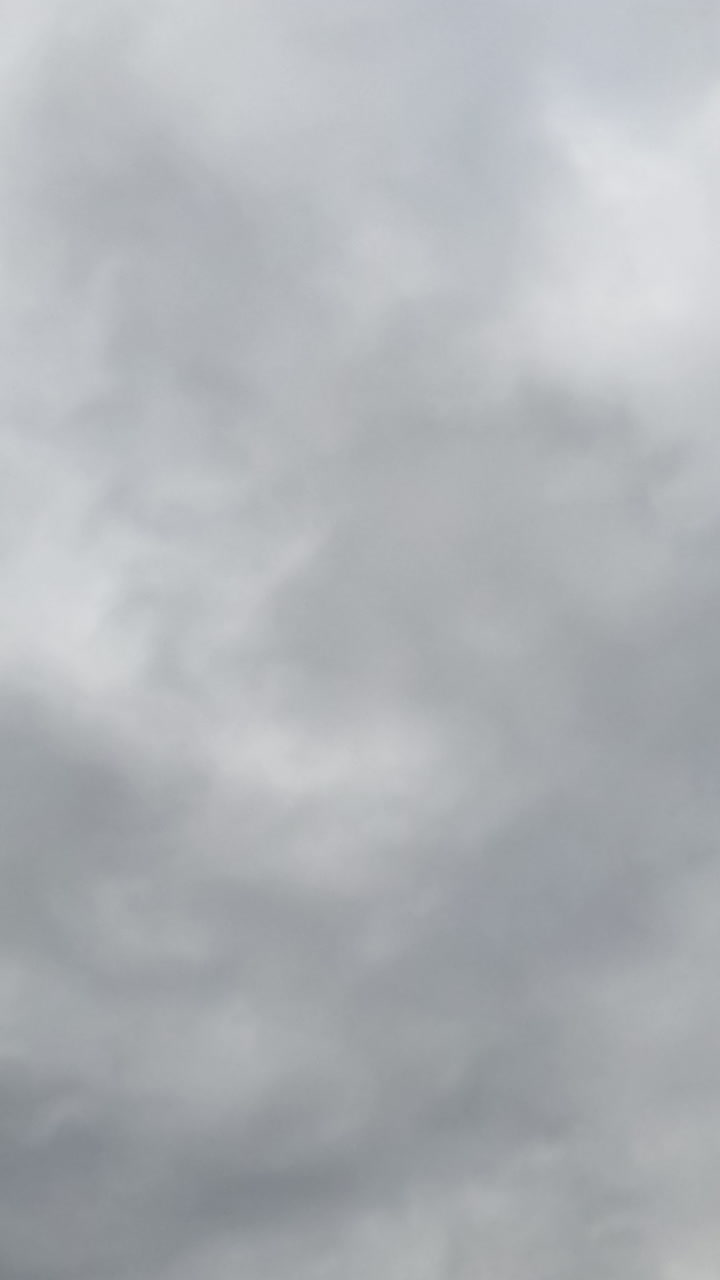 Dramatic cloudscape forming in the skies. Rainy clouds move in the atmosphere. Low angle view. Timelapse. Vertical video