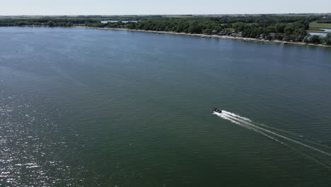 Seguimiento-Aéreo-De-Un-Barco-En-Marcha-Avanzando-En-Un-Lago-Del-Medio-Oeste-De-Iowa