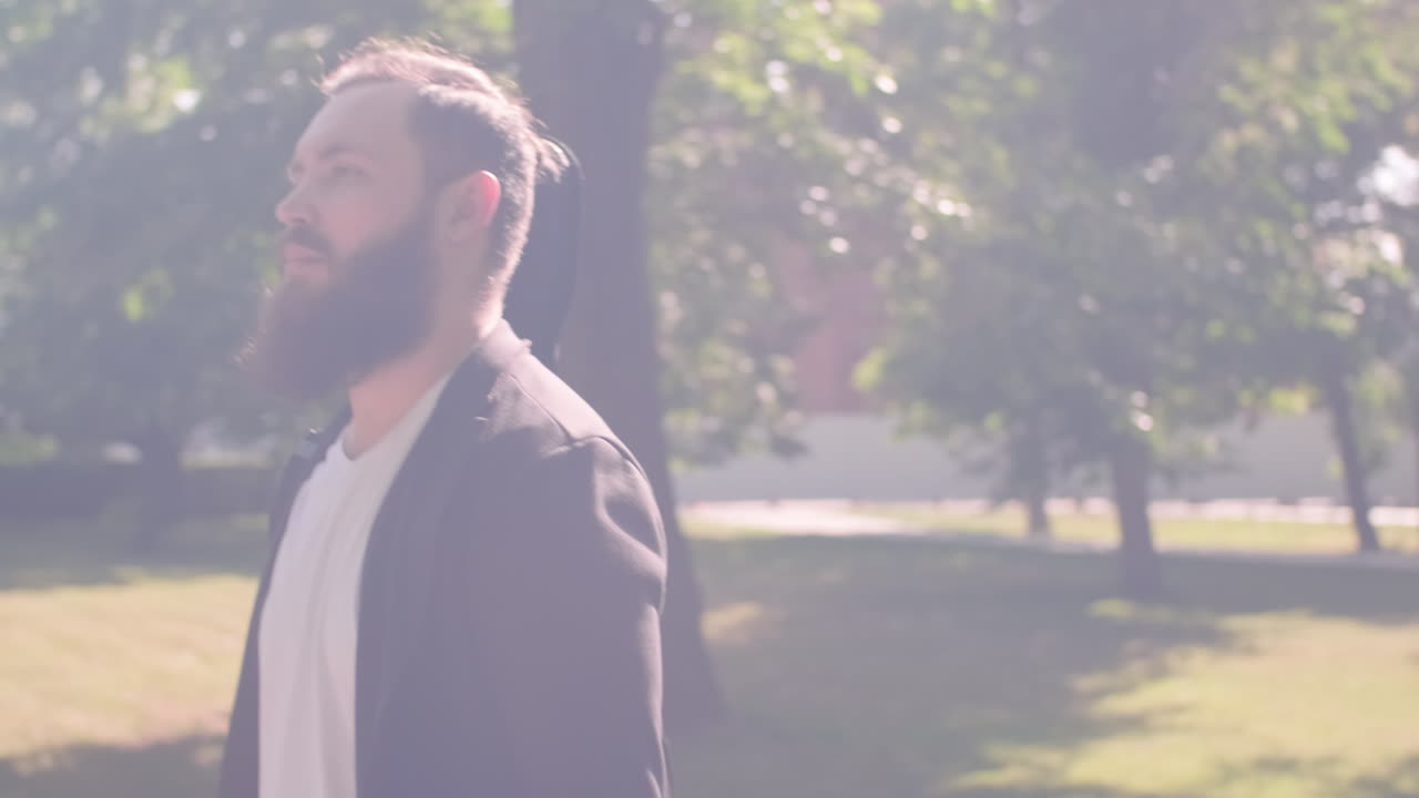 Musician with Guitar Walking through Park