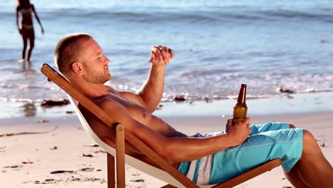 un joven sentado en la playa.