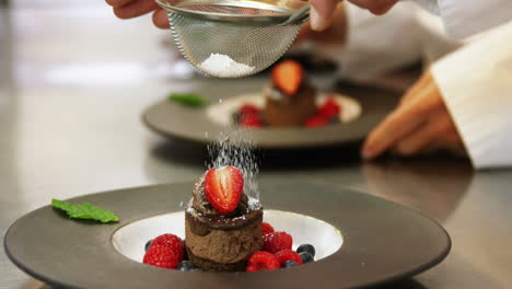 chefs putting finishing touch on desserts