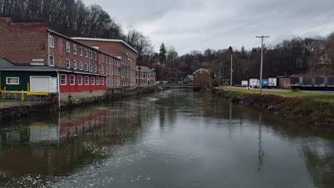 Old-brick-buildings-in-an-industrial-park-with-a-creek-in-small-town-USA