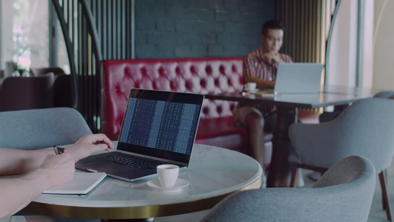 Entrepreneur Analyzing Stocks on Laptop in Cafe