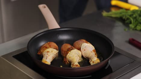 frying chicken drumsticks in a pan