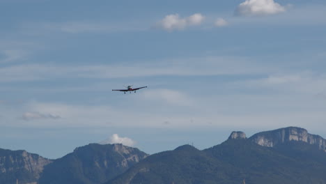 propeller airplane flies over alpine meadow