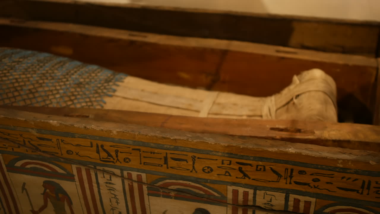 Piedi di sarcofago di un'antica mummia egizia esposti in una mostra museale, che mostrano intagli dettagliati e texture invecchiate in primo piano