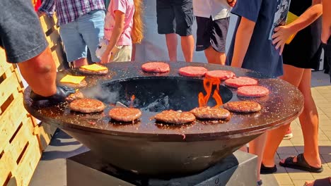 Outdoor barbecue with burgers on a grill, lively social gathering vibe