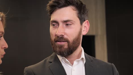 business meeting of three investors. discussion communication teamwork collaboration in the meeting room. close up face of bearded adult man talking about investment wearing suit looking intelligent.