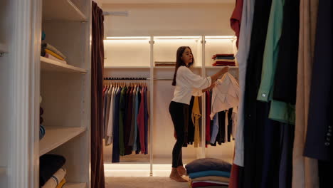 woman choosing clothes in a stylish walk-in closet
