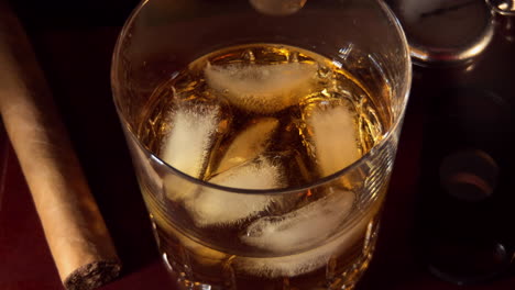 Slow-motion-of-whiskey-being-stirred-with-ice-in-glass