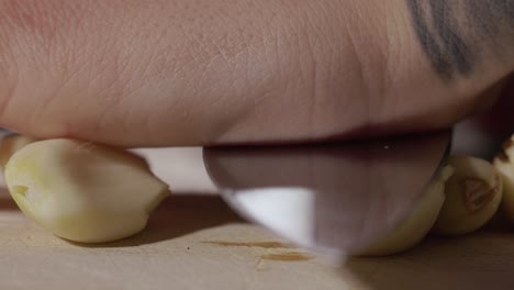 pressing garlic with a kitchen knife - macro shot