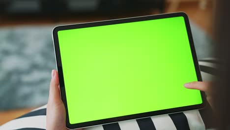 close up de mujer sosteniendo en las manos una tableta digital con pantalla verde para internet en línea, pantalla chromakey para publicidad.