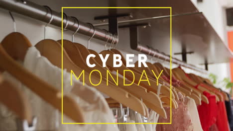 cyber monday text animation over clothes hanging on wooden hangers in store
