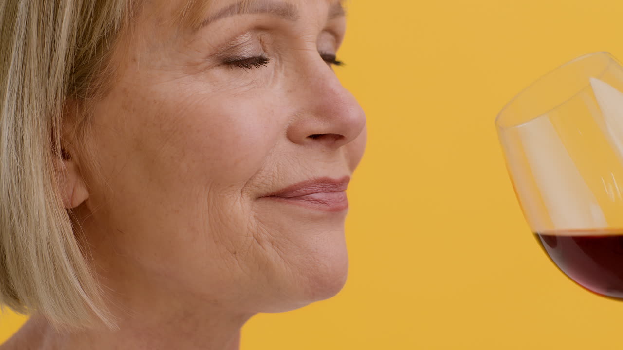 mujer madura disfrutando de un vaso de vino rojo