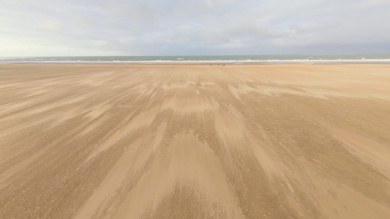 네덜란드의 빈 해변에 장비를 설치하는 카이트서퍼들