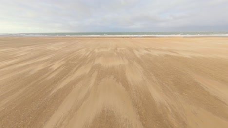 kitesurfers setting up their equipment on a empty beach in the netherlands