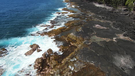 fpv slomo drone disparó sobre el océano azul estrellándose en la costa de basalto