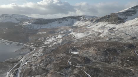 the old man of storr on the isle of skye, scotland, with snow-dusted landscapes and winding roads, aerial view