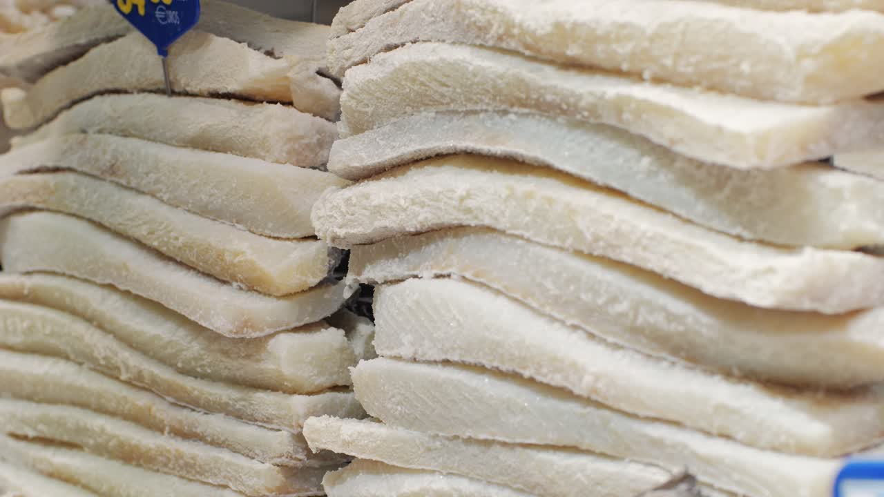 Fresh white fish fillets artfully and neatly arranged in a grocery store display for customers to browse