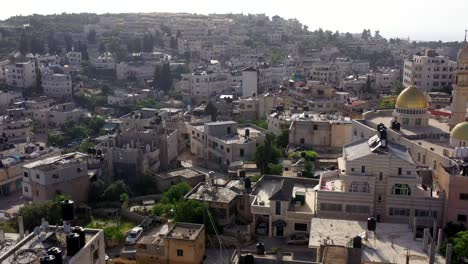 aerial view of a middle eastern town with a golden-domed mosque and minaret