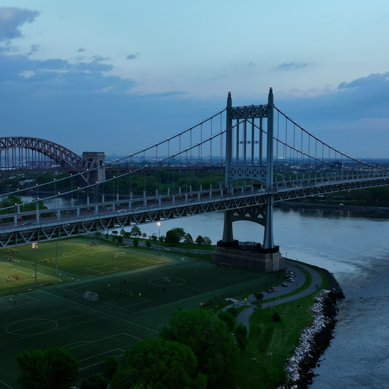 Beautiful Triborough Bridge with football pitches underneath. Hell Gate Bridge at backdrop. Bridges of New York in the evening